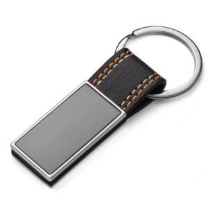 Chaveiro Metal CB 14999 | em níquel brilhante com alça em PU, chapinha frente e verso em grafite lisa.